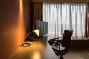 a chair sitting in front of a window next to a lamp at De Keyser Hotel in Antwerp