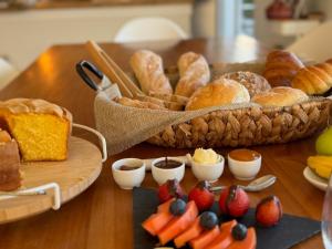 a table with pastries and fruit and a basket of bread at Profetas GuestHouse in Porto Santo