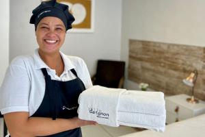 a woman is holding a stack of towels at Pousada Villegaignon in Búzios +116 photos