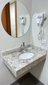 uma casa de banho com um lavatório e um espelho em Hotel Fly - Aeroporto Cuiabá em Várzea Grande