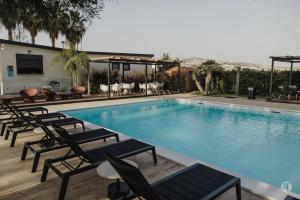 a swimming pool with lounge chairs next to a building at B&B Villa Seta in Agrigento