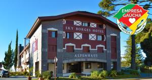 a building with a sign in front of it at Sky Borges Hotel Alpenhaus - Gramado in Gramado