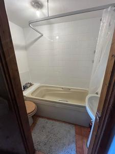 La salle de bains est pourvue d'une baignoire, de toilettes et d'un lavabo. dans l'établissement Mandarin Cottage- quirky upside down retreat - Norfolk, à Mileham