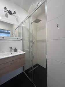 a bathroom with a glass shower and a sink at Apartament Giulia z balkonem in Oleśnica +15 photos