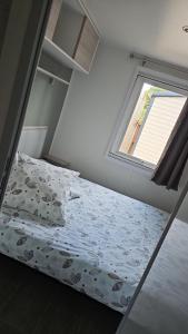 a small bedroom with a bed and a window at Mobil home les sables d'or in Cap d'Agde