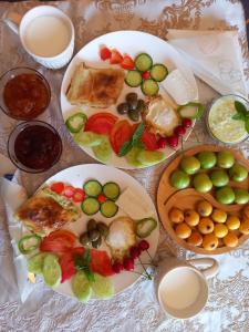 une table avec des assiettes de nourriture et des bols de fruits dans l'établissement Vila Dean, à Berat