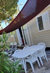 una mesa blanca y sillas en un patio en Mobil home les sables d'or, en Cap d'Agde