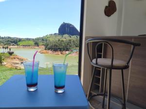 two drinks sitting on a table with a bar stool at Cabaña Estancia Primavera in Guatapé