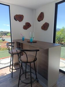 a bar with two stools and two glasses on the wall at Cabaña Estancia Primavera in Guatapé +23 photos