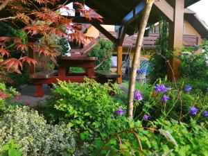 a garden with a bench and some flowers at Pod Jednym Dachem in Skawa