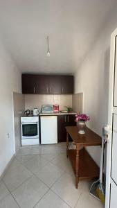 a small kitchen with white appliances and a table at Sea in Ulcinj
