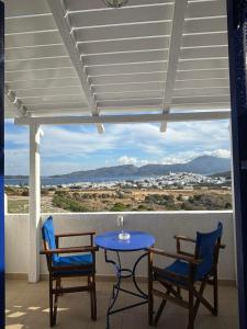 una mesa y sillas en un balcón con vistas en Kapetan Giannis, en Adamas