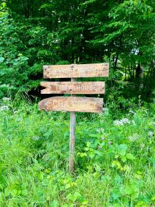 a wooden sign in the middle of a field at Chatičky u Dlouhé řeky in Buchlovice