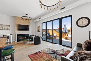 a living room with a fireplace and a clock on the wall at Alpenglow Retreat in Whitefish