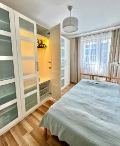 sypialnia z dużym łóżkiem i oknem w obiekcie Nowoczesny apartament blisko centrum Warszawy z podziemnym garażem i bardzo szybkim WiFi oraz balkon w mieście Ząbki