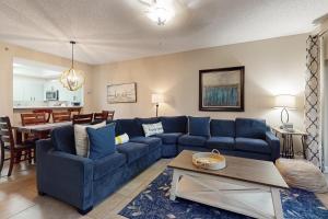 a living room with a blue couch and a table at TOPS'L Summit 210 in Destin