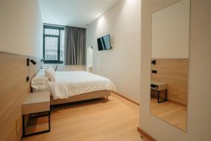 un dormitorio con una cama y un espejo en Mouritz Rooms, en Negreira