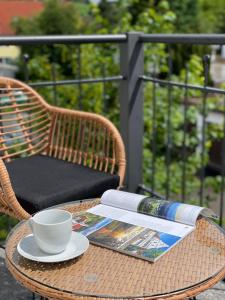 una mesa con una taza y un libro y una taza y una taza de café en Ferienwohnung Ottobeuren en Ottobeuren