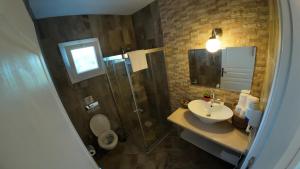 a bathroom with a sink and a shower and a toilet at Adelfia Hotel in Alaçatı