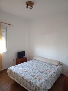 1 dormitorio con 1 cama y TV. en Islantilla Club Golf, en Huelva