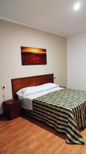 Hotel Nicolaj في بولينيانو آ ماري: غرفة نوم بسرير ودهان على الحائط