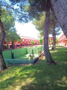 einen Tennisplatz in einem Park mit Bäumen in der Unterkunft Islantilla Club Golf in Huelva