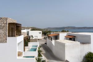 a view of a white house with the ocean in the background at Boho Sapiens Sea View in Adamas