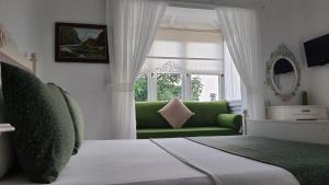 salon z zieloną kanapą i oknem w obiekcie Adelfia Hotel w mieście Alaçatı