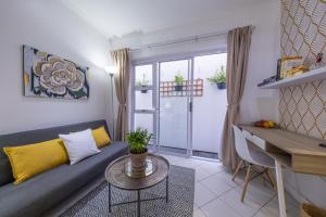 a living room with a couch and a table at Cosy and Central in Claremont in Cape Town