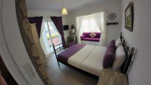 a bedroom with a large bed with purple pillows at Adelfia Hotel in Alaçatı +26 photos