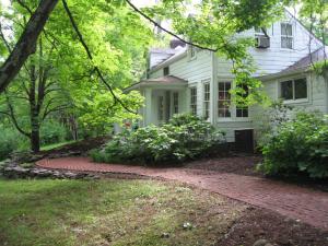 a white house with a brick walkway in front of it at B&B on seven acres with private bed & bath in Clinton Corners