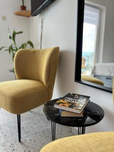 a living room with a table and a chair and a mirror at Ema Rooms in Novi Vinodolski +41 photos