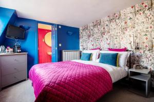 a bedroom with a pink bed and blue walls at Harington's Boutique Hotel in Bath