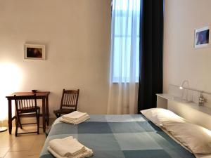 a bedroom with a bed and a table and a window at castle apartment in Bari