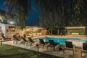 ein Pool in der Nacht mit Stühlen und einem Sofa in der Unterkunft B&B Villa Seta in Agrigento