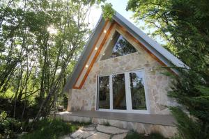 a tiny house in the woods with a large window at Vukova dolina in Cetinje