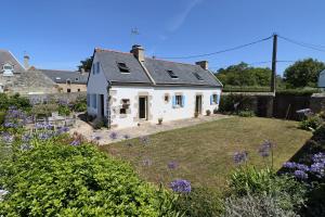 a white house with a yard with purple flowers at 391-Authentique penty, vue mer, proche plage in Primelin