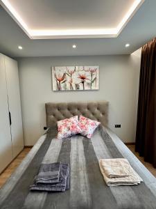 a bedroom with a large bed with two towels on it at Apartment G17 in Pernik