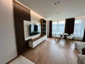 a living room with a television and a table at Apartment G17 in Pernik