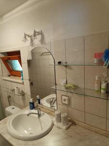 een badkamer met een wastafel, een toilet en een spiegel bij Ubytovanie Hrabiny in Sučany