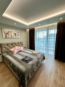 a bedroom with a large bed and a large window at Apartment G17 in Pernik