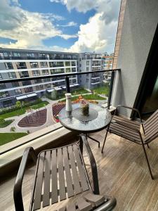 a balcony with a table and chairs and a view of a building at Apartment G17 in Pernik