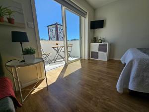 1 dormitorio con cama y vistas a un balcón en Fascinante Orbita Apartments, en Vila Nova de Famalicão