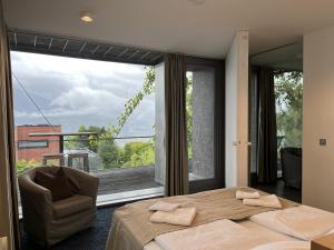 ein Schlafzimmer mit einem Bett und einem Stuhl sowie einem großen Fenster in der Unterkunft Holidayhome Elza in Innsbruck