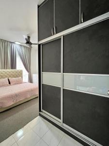 een slaapkamer met een bed en een grote glazen kast bij The Comfy Stay in Kuala Lumpur