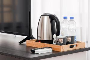 a coffee maker and water bottles on a desk at Denis Hotel in Prizren