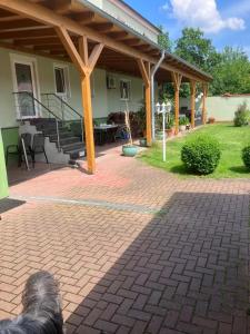 a dog laying on a brick patio in front of a house at Chausseehaus - Ferienwohnungen Rottleberode am Harzrand in Rottleberode