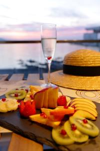 a plate of fruit on a table with a glass of wine at Da Luz Boutique Hotel in Sarandë