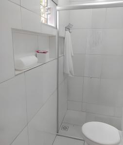 a white bathroom with a toilet and a shower at Apto n.09 condominio custo beneficio. in Brasília