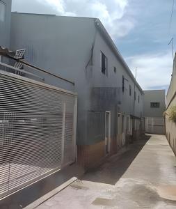 a white building with a gate and a fence at Apto n.09 condominio custo beneficio. in Brasília